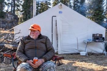 man sitting in front of his tent